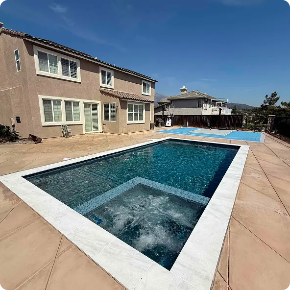 Luxury residential pool area with built-in hot tub and spacious patio