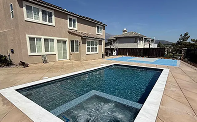 Two-story home with spacious backyard featuring a clear blue swimming pool and built-in spa